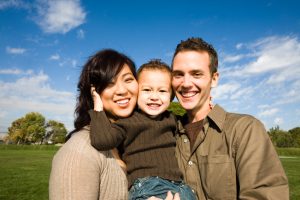 smiling couple holding child